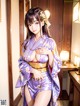 A woman in a purple kimono is posing for the camera.