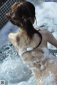 A woman is taking a bath in a hot tub.