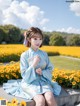 A woman in a blue dress sitting on a bench in a field of flowers.