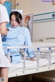 A woman in a hospital bed with a nurse standing next to her.