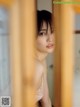 A woman in a white lingerie looking out of a window.