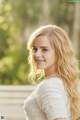 A beautiful young woman in a white dress posing for a picture.